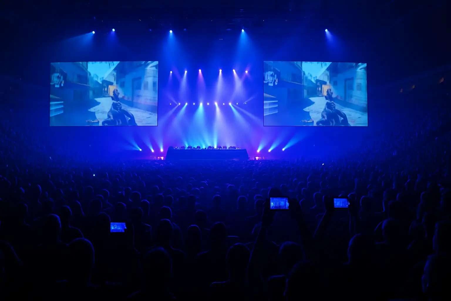 A large esports arena screen showing a live competitive gaming broadcast with a crowd watching