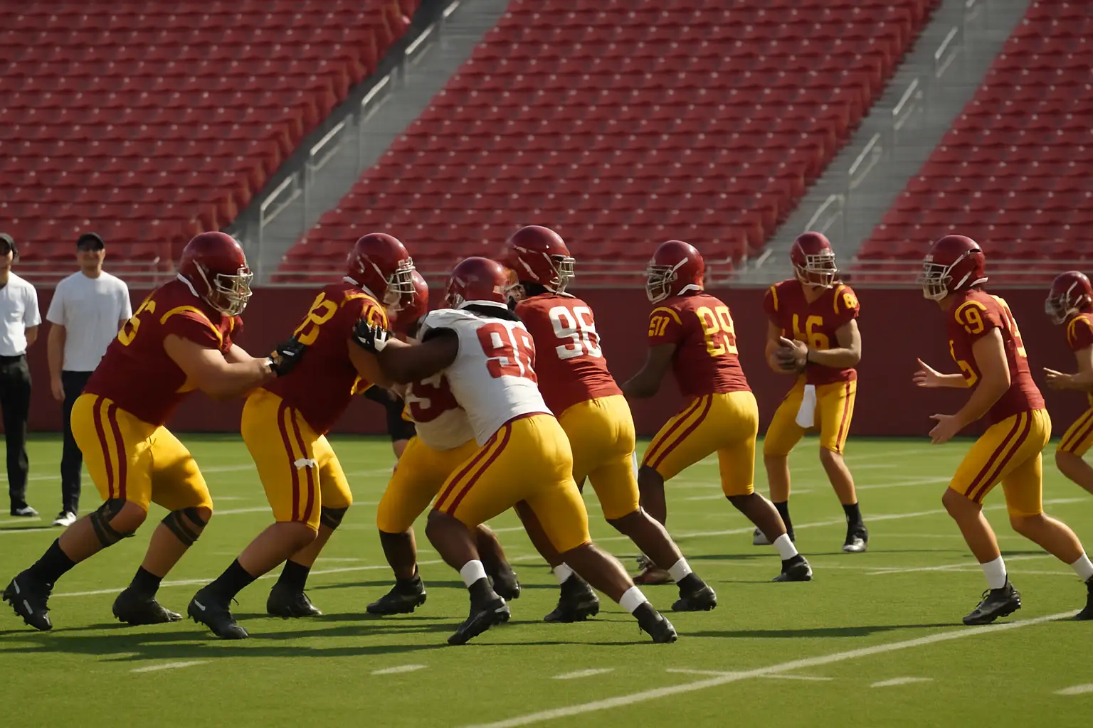 USC Trojans football players running drills on a sunlit college football field during practice