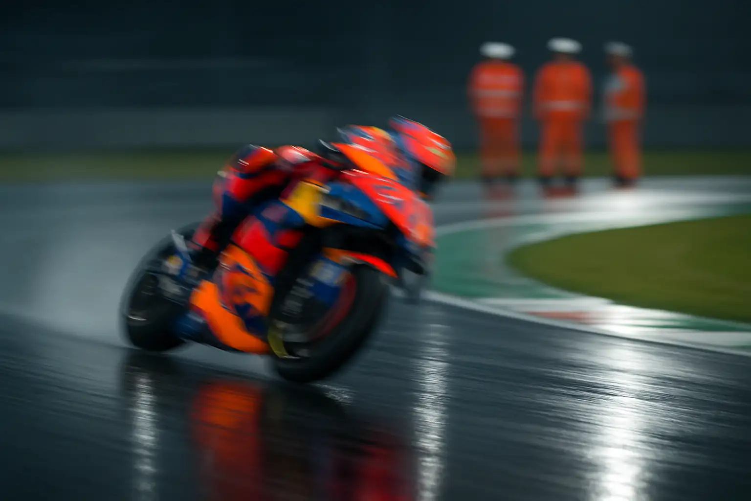 A MotoGP rider on a prototype bike navigating a fast corner at a European circuit